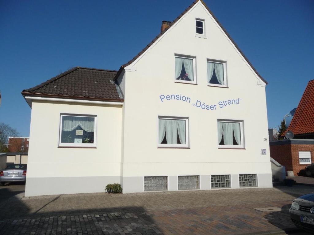 un edificio blanco con las palabras pasión unido estación en él en Pension Döser Strand, en Cuxhaven