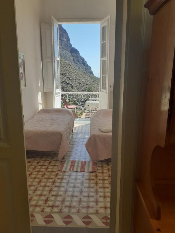 a room with two beds and a view of a mountain at Casa Escuela in Valle Gran Rey
