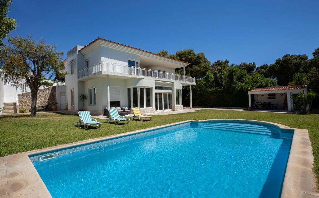 a large swimming pool in front of a house at Estoril dream in Estoril