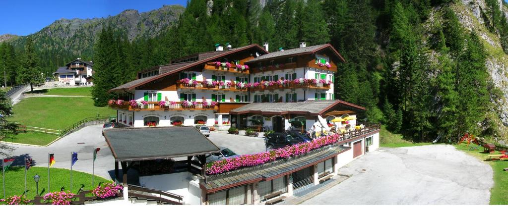 a large building with flowers on the balconies of it at Hotel Roy in Malga Ciapela