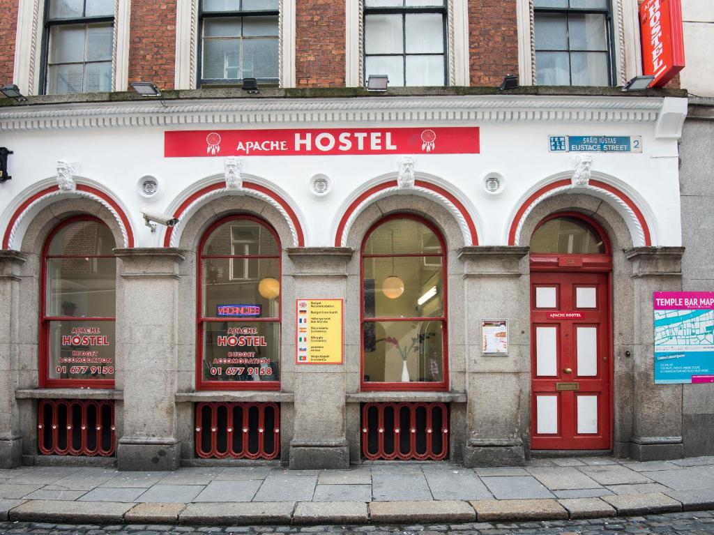 a building with red doors and windows on a street at The Apache Hostel in Dublin