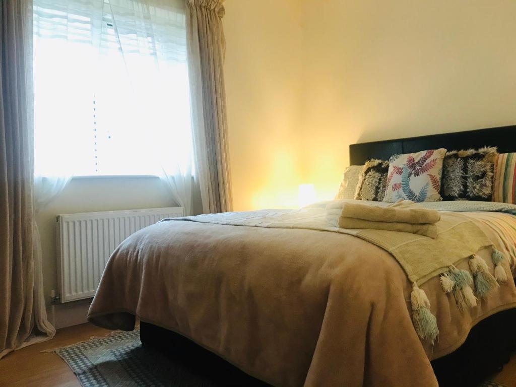 a bedroom with a bed with a large window at Letterkenny Town Centre Apartment in Letterkenny