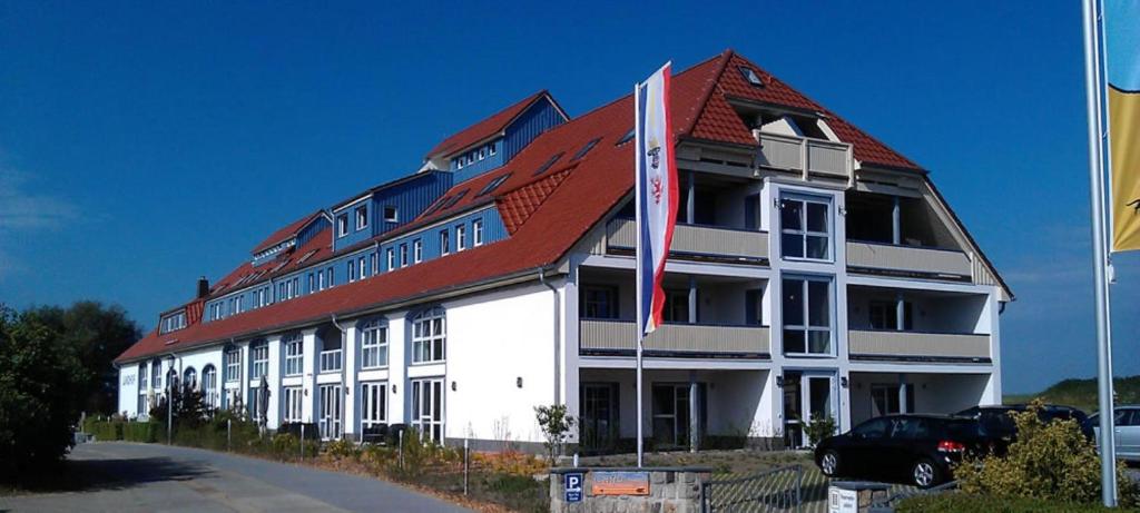 a large white building with a red roof at Der Landhof Schwalbennest LH-204 in Stolpe auf Usedom