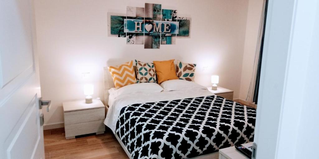 a bedroom with a bed with a black and white comforter at relax house in Genoa