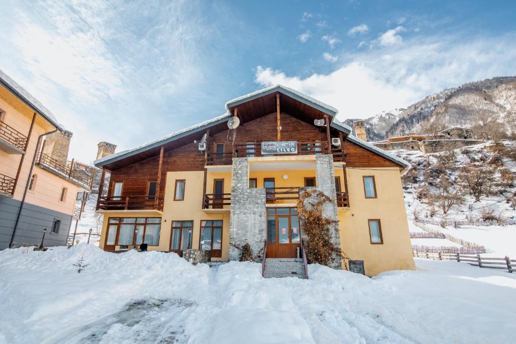 un bâtiment avec de la neige devant lui dans l'établissement Hotel Lileo, à Mestia