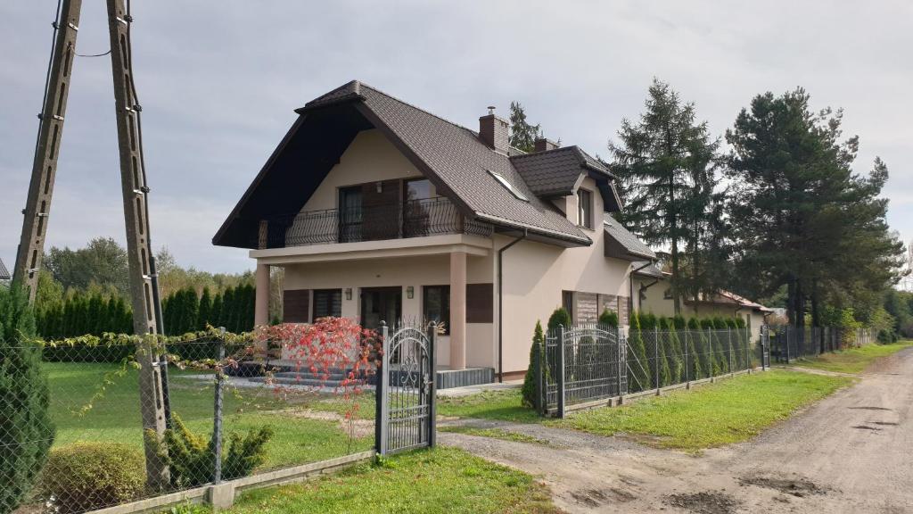 una casa blanca con techo negro y puerta en DobraNocka, en Kaleń