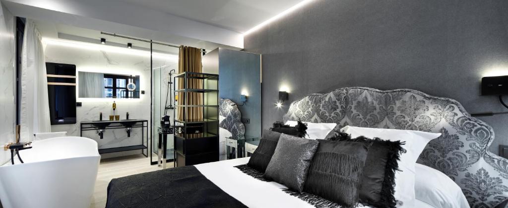 a bedroom with a king sized bed and a bathroom at Pension Ama Bilbao in Bilbao