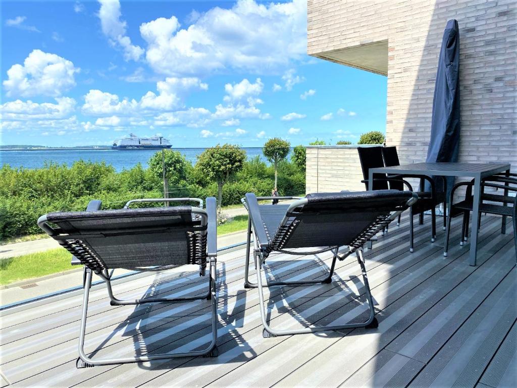 a patio with a table and chairs on a deck at Meeresrauschen in Laboe