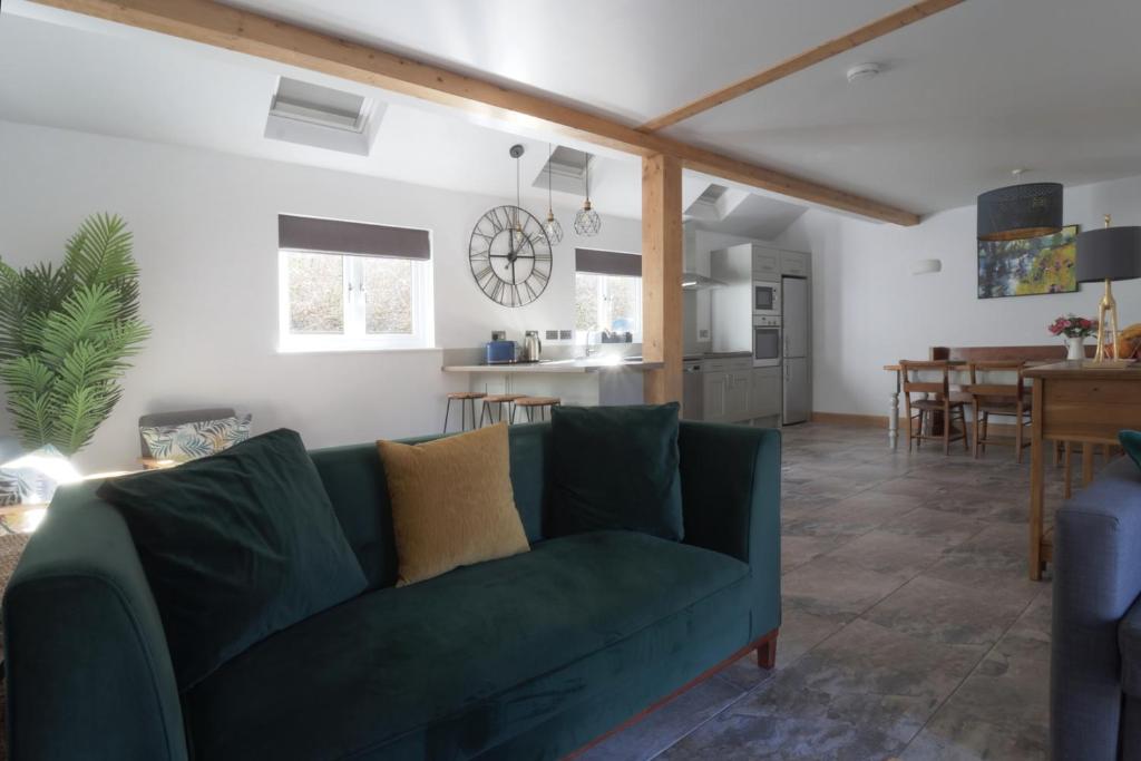萊德林赫的住宿－The Hayloft，一间带绿色沙发的客厅和一间厨房