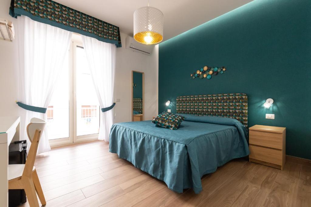 ein Schlafzimmer mit einem Bett und einer blauen Wand in der Unterkunft Napolilive B&B in Neapel