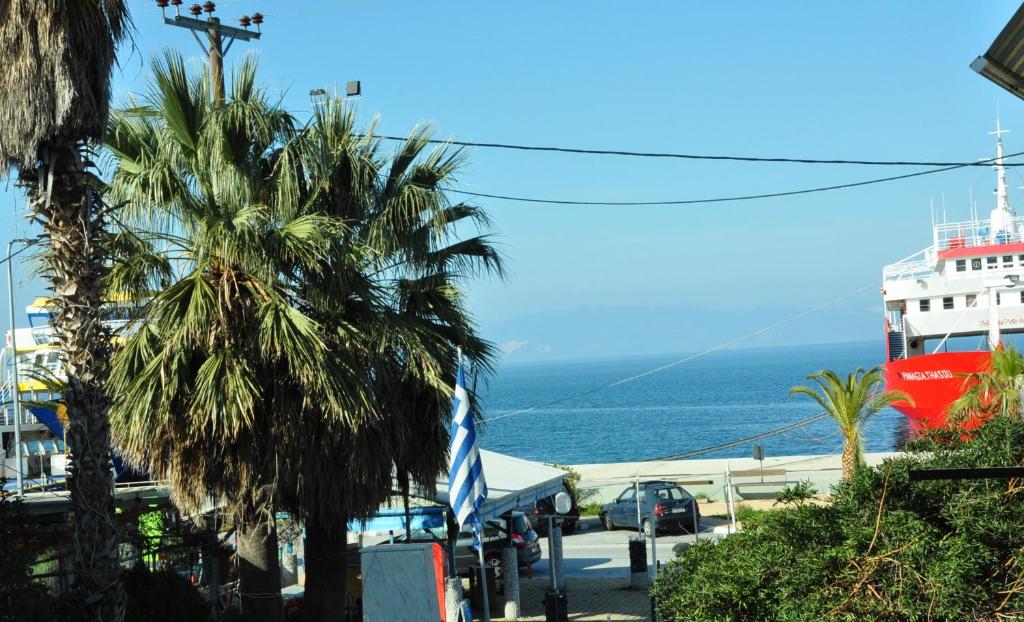 een cruiseschip geparkeerd naast de oceaan met palmbomen bij Hotel Medusa in Skala Prinou