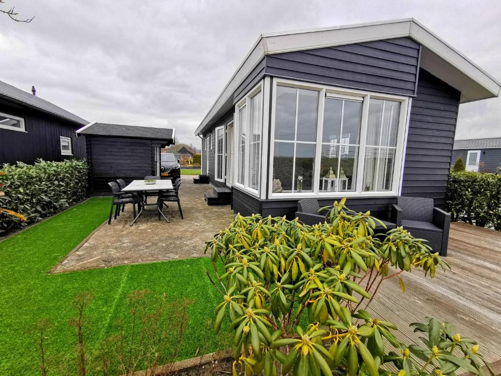 a tiny house with a patio and a table at Giet Oan gelegen op Resort Venetië in Giethoorn