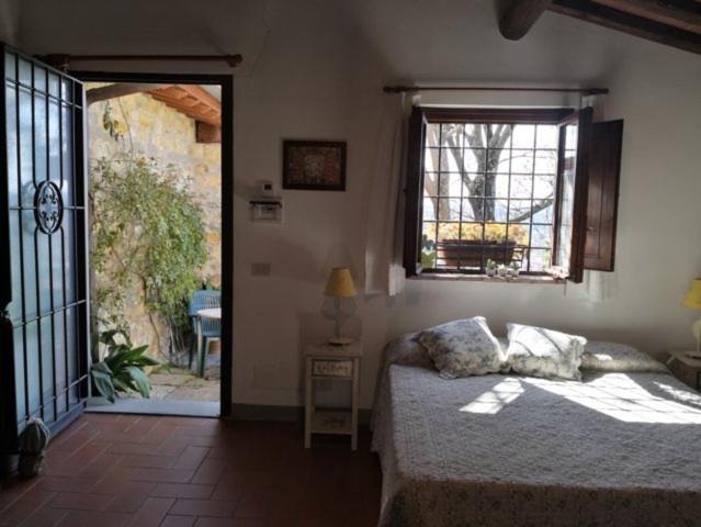 Schlafzimmer mit einem Bett und einem Fenster in der Unterkunft Agriturismo Biologico Poggiopiano in Fiesole