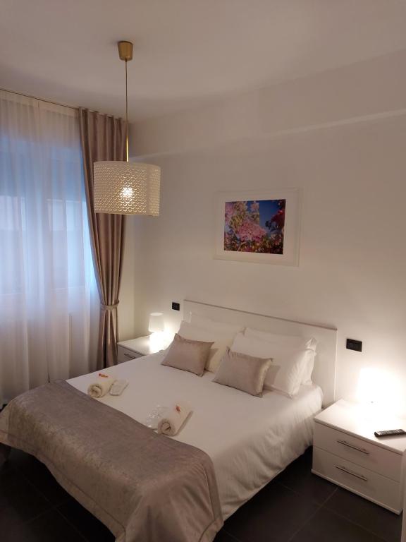 sypialnia z dużym białym łóżkiem i lampką w obiekcie Cà Sottomarina gli Appartamenti in Centro Apartsuite w mieście Sottomarina