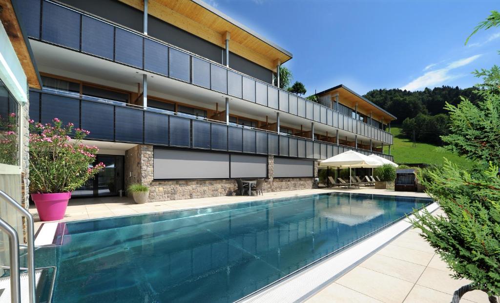 a swimming pool in front of a building at St Hubertus BnB in Egg