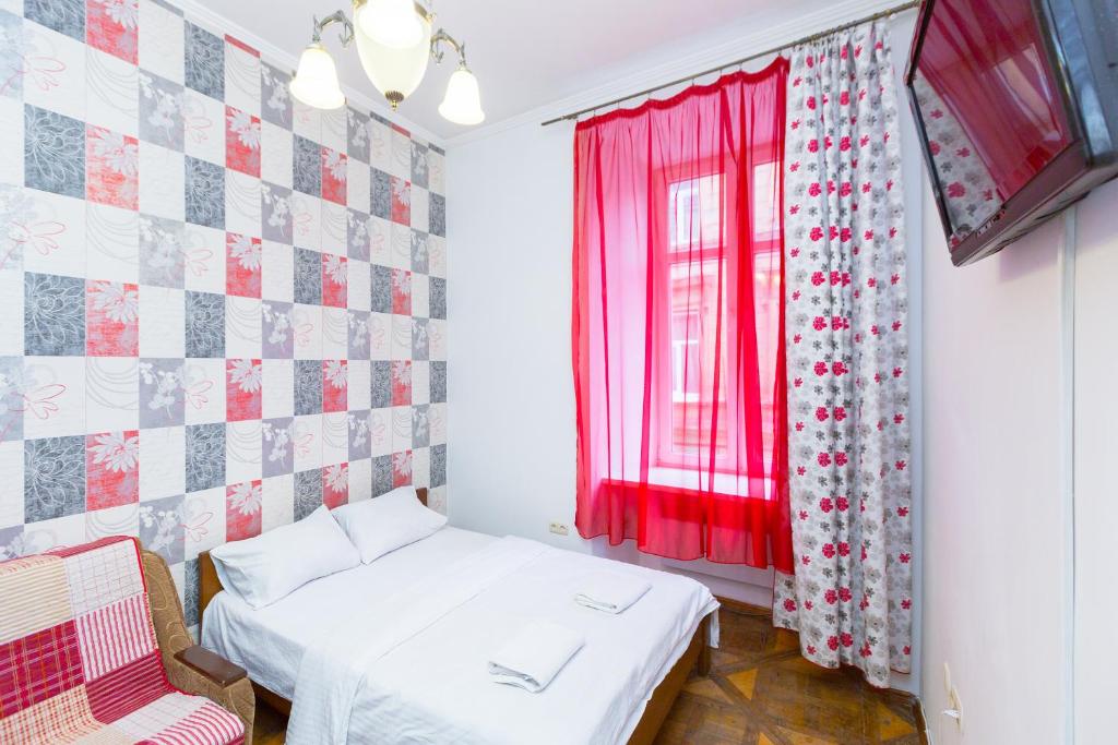 1 dormitorio con 1 cama y una ventana con cortinas rojas en Квартира на вулиці Краківській 34, en Leópolis
