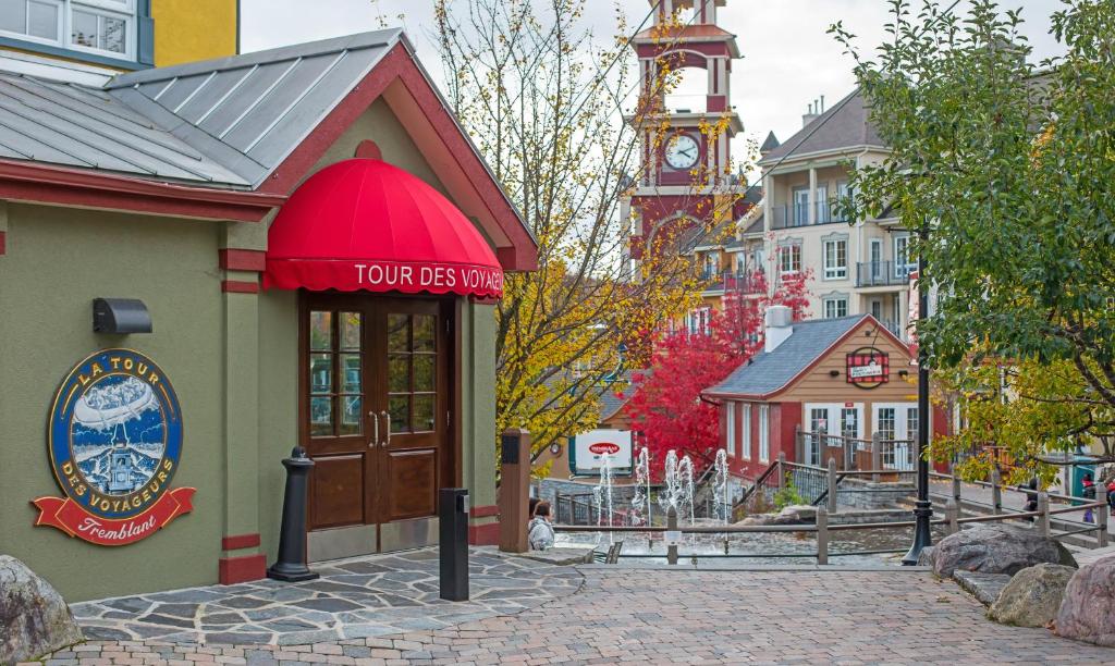 a building with a clock tower in a city at La Tour des Voyageurs II in Mont-Tremblant