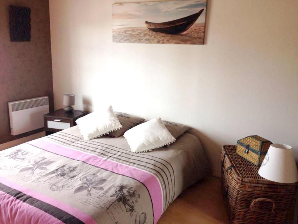 a bedroom with a bed and a picture of a boat at Villa de 4 chambres avec piscine privee jardin clos et wifi a Aytre a 5 km de la plage in Aytré