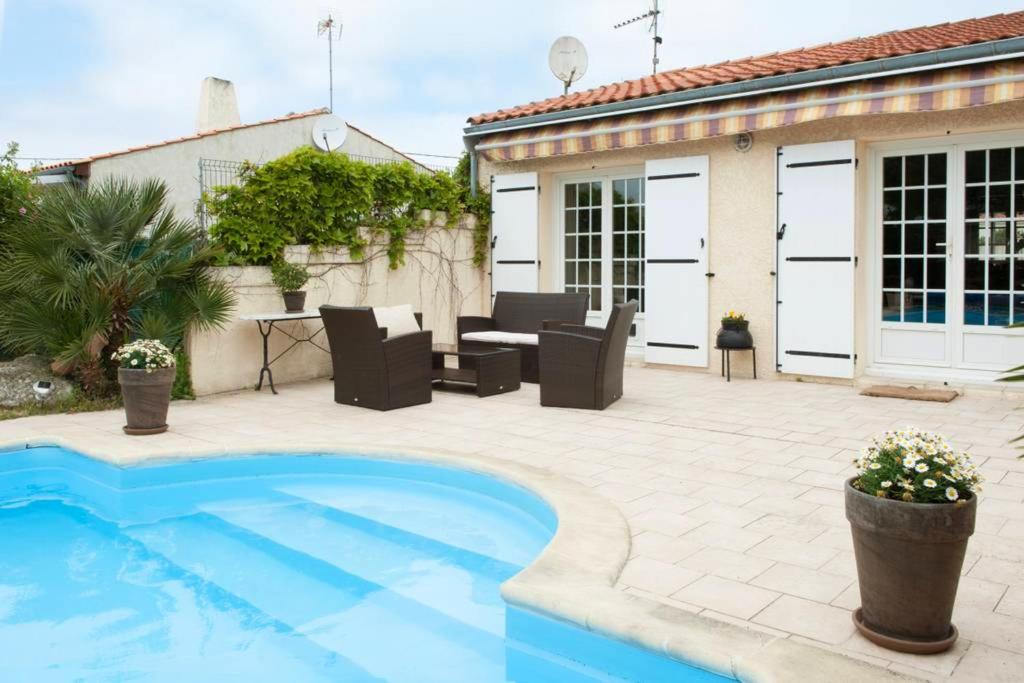 a patio with a swimming pool and a house at Villa de 4 chambres avec piscine privee jardin clos et wifi a Aytre a 5 km de la plage in Aytré