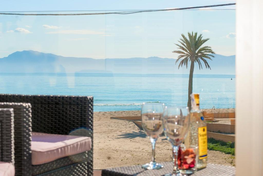 una mesa con dos copas de vino y una palmera en la playa en Apartment Paradise Bay 3 at Alcudia Beach, Salzes 3 en Playa de Muro