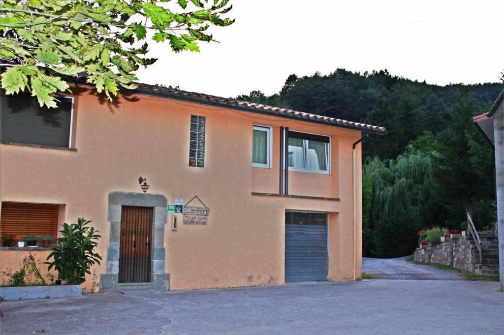 une grande maison avec une porte et un garage dans l'établissement Turisme Rural El Janpere, à Sant Joan de les Abadesses