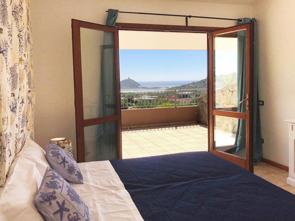 a bedroom with a bed and a large glass door at Sa Tirìa in Chia