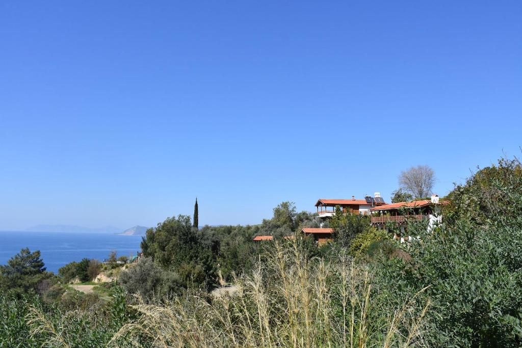 a house on a hill with the ocean in the background at Casa Roja in Faralya