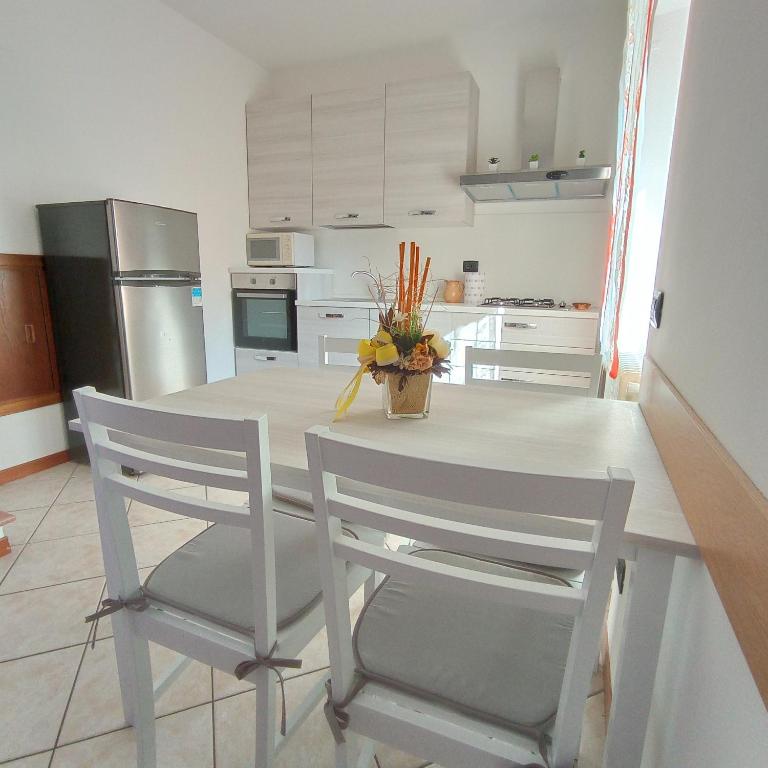 a kitchen with a table with two chairs and a refrigerator at LITTLE FLOWER in Domaso