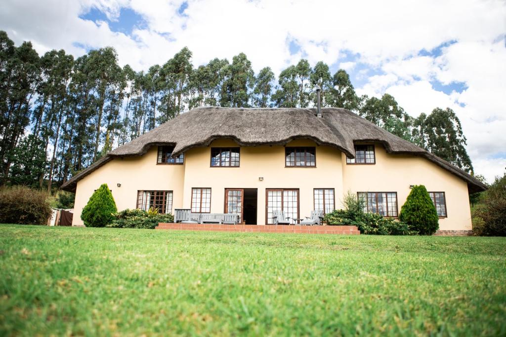 a large house with a thatched roof at Graceland Farm in Underberg
