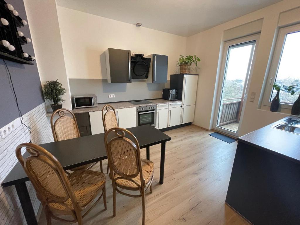 - une cuisine et une salle à manger avec une table et des chaises dans l'établissement Joanna Apartment - MA Rheinau 2, à Mannheim