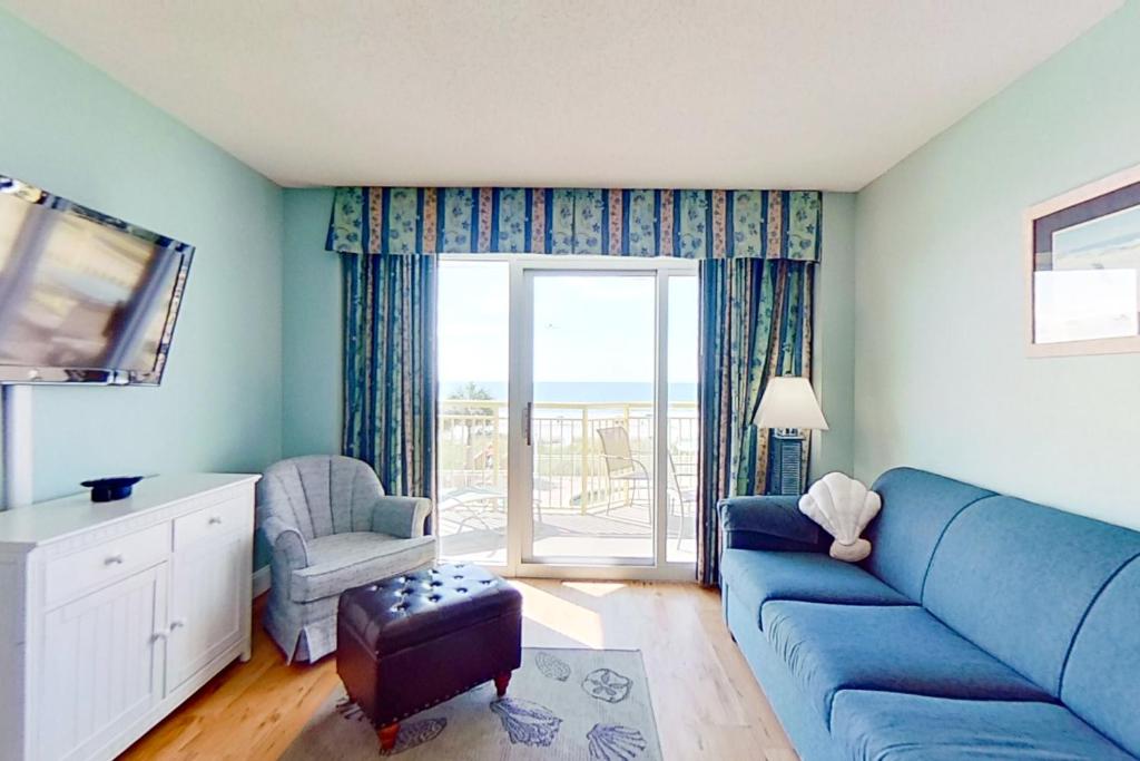 uma sala de estar com um sofá azul e uma janela em Bay Watch 0232 em Myrtle Beach