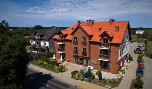 una casa grande con techo naranja en una calle en Apartament prywatny Lazurowy, en Sztutowo