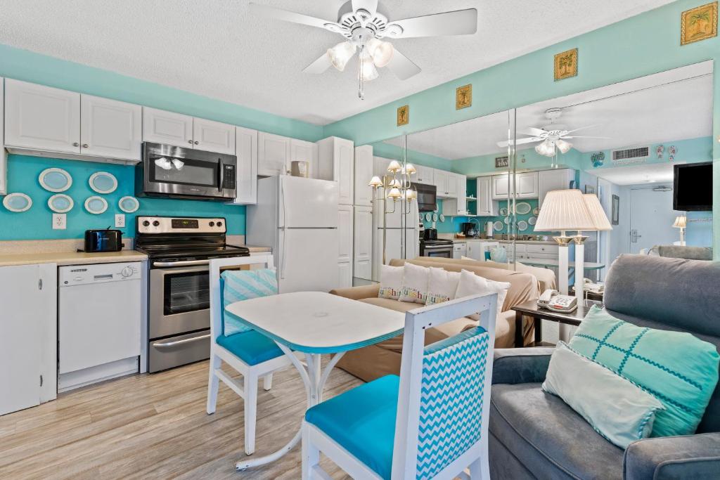 uma cozinha e sala de estar com mesa e cadeiras em Bay Watch 0631 em Myrtle Beach