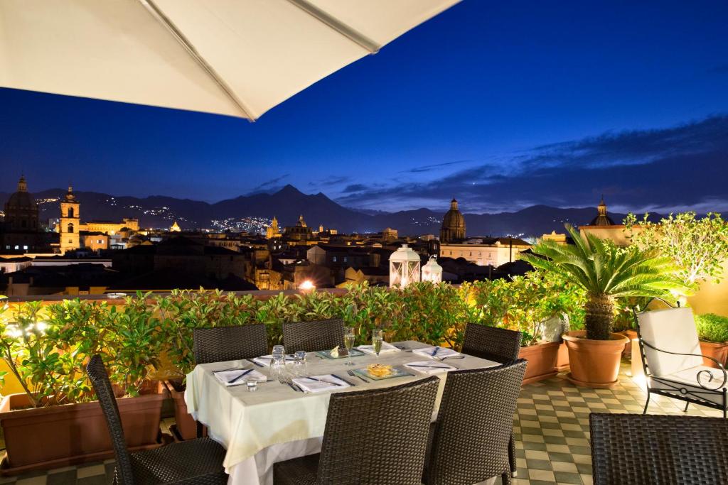 a table on a balcony with a view of the city at Hotel Ambasciatori in Palermo