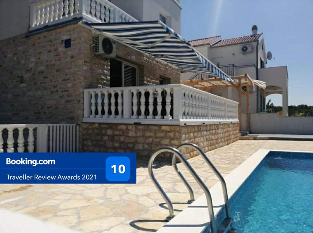 a villa with a swimming pool and a house at Kuća za odmor Postonjski in Maslenica