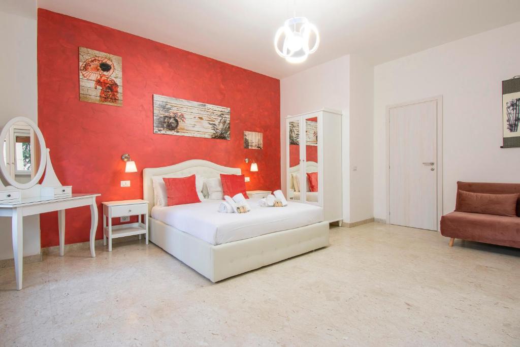 a bedroom with a white bed and a red wall at Luxury Boutique Hotel in Rome