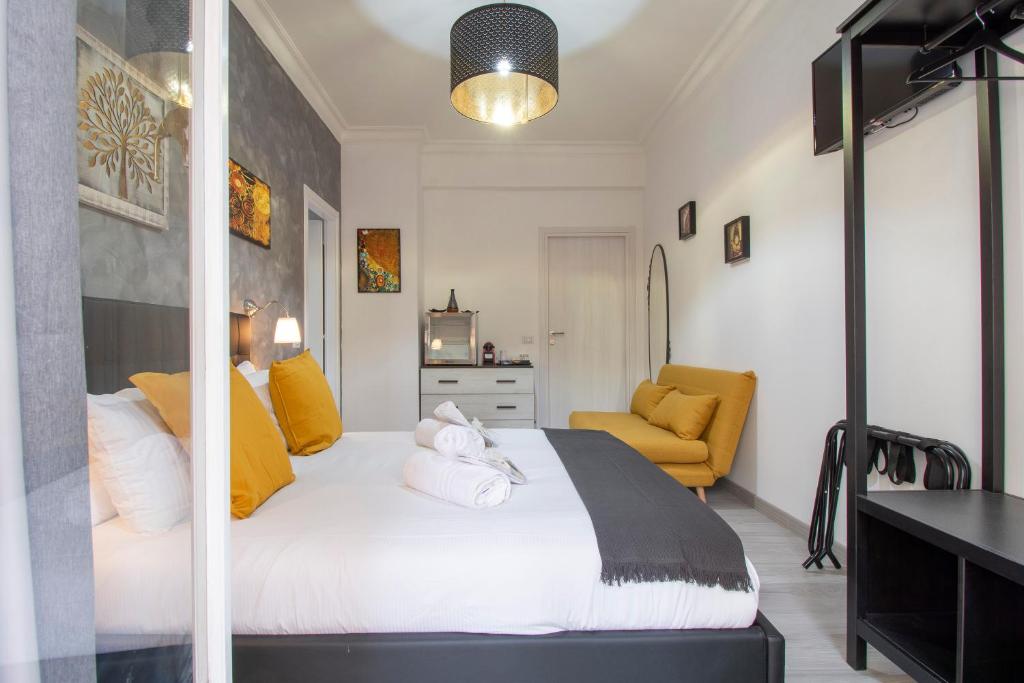 a bedroom with a large white bed and a yellow chair at Luxury Boutique Hotel in Rome
