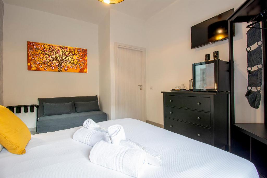 a bedroom with a white bed and a couch at Luxury Boutique Hotel in Rome