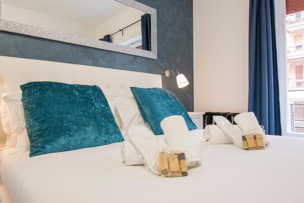 a bedroom with a white bed with blue pillows at Luxury Boutique Hotel in Rome