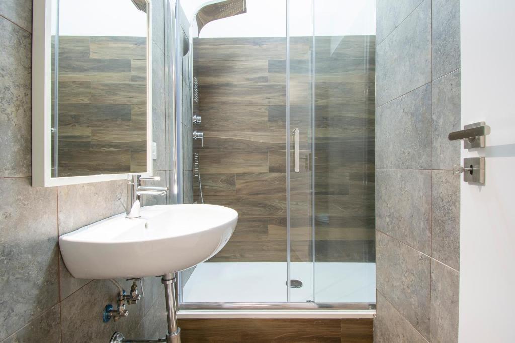 a bathroom with a sink and a glass shower at Luxury Boutique Hotel in Rome