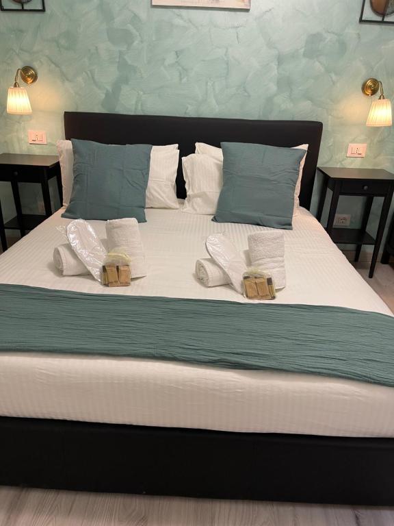 a large bed with white sheets and blue pillows at Luxury Boutique Hotel in Rome