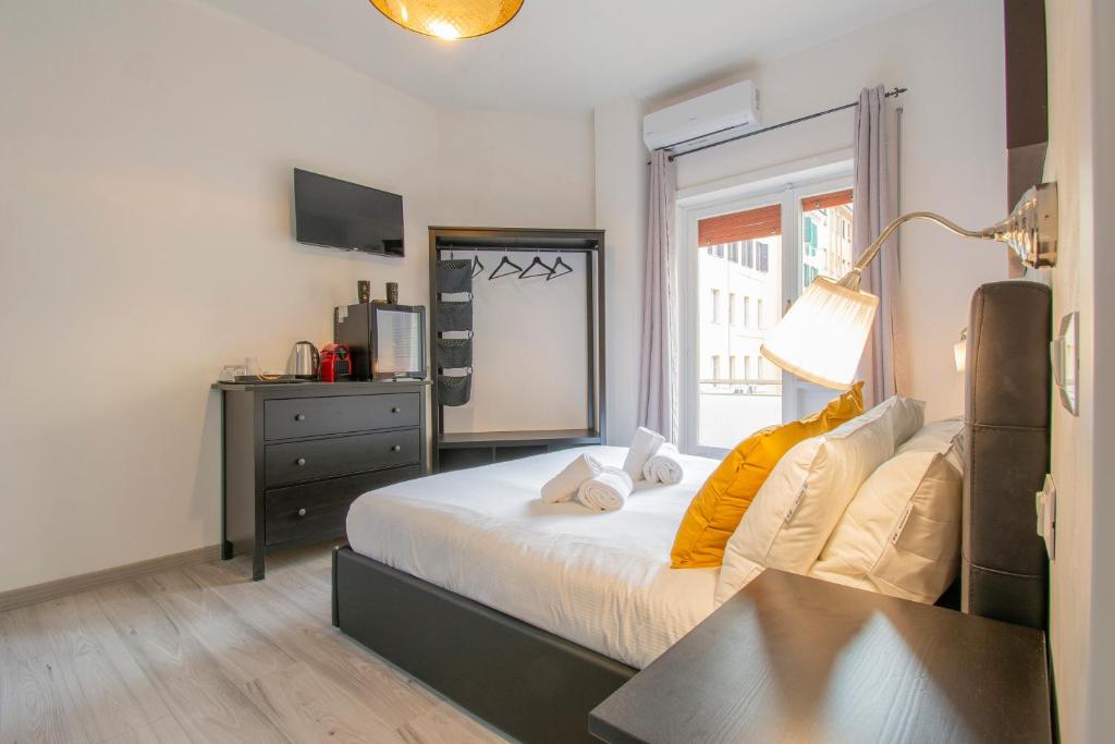 a bedroom with a bed and a dresser and a window at Luxury Boutique Hotel in Rome
