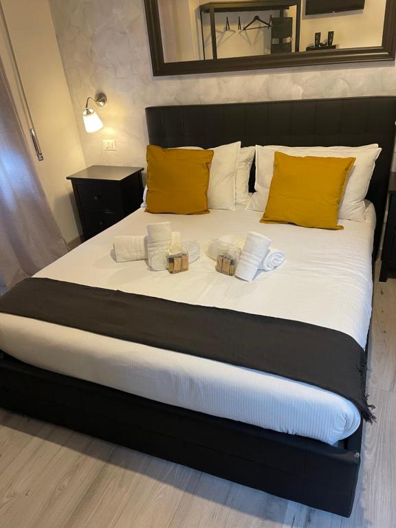a bed with yellow pillows and two candles on it at Luxury Boutique Hotel in Rome