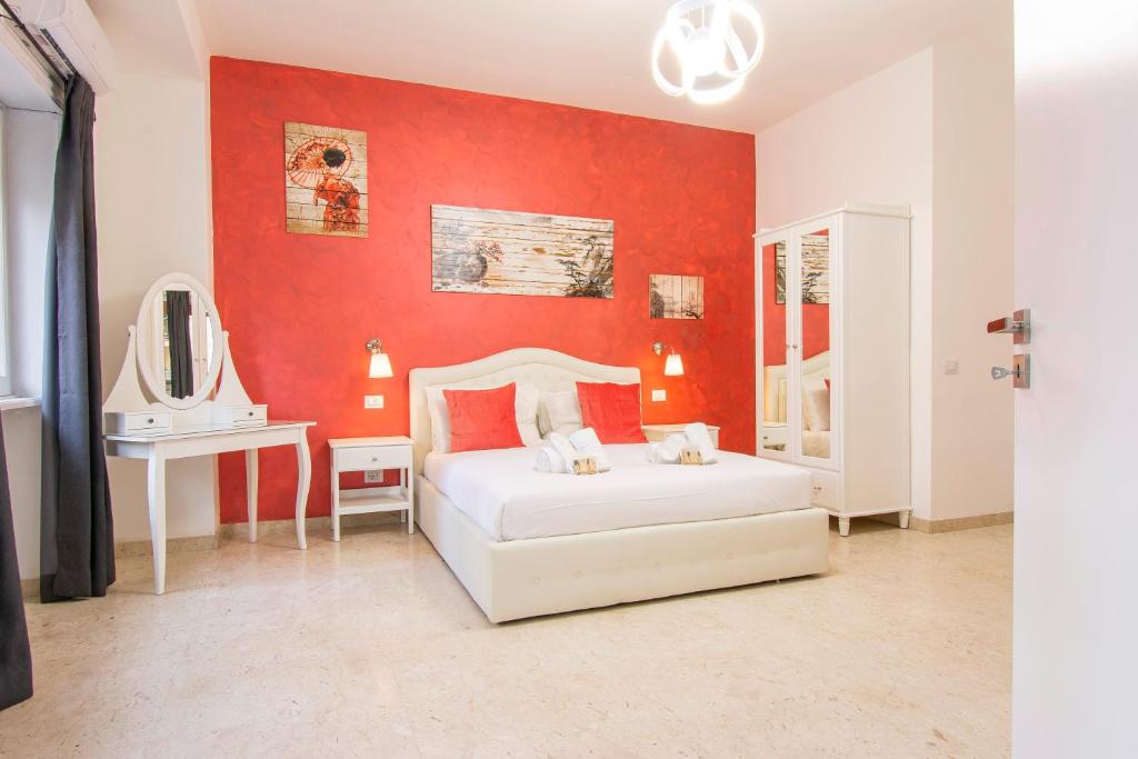 Luxury Boutique Hotel في روما: غرفة نوم بسرير ابيض وجدار احمر