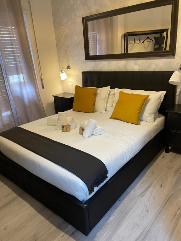 a large bed with yellow pillows and a mirror at Luxury Boutique Hotel in Rome
