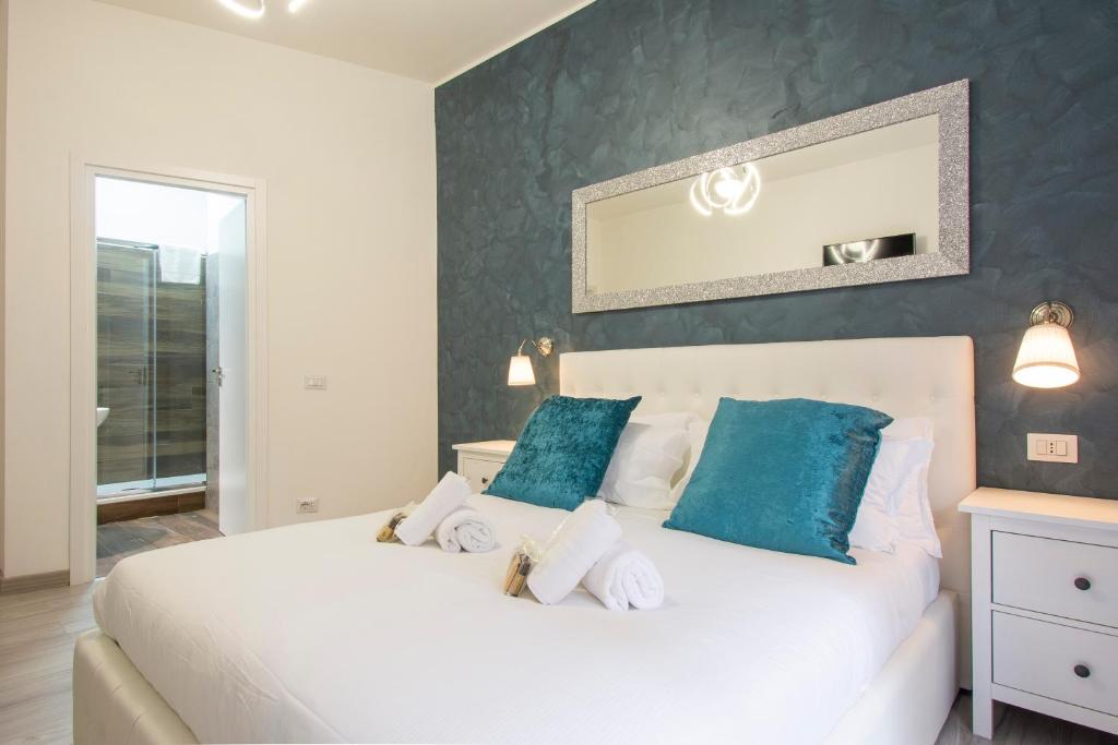 a bedroom with a white bed with blue pillows at Luxury Boutique Hotel in Rome