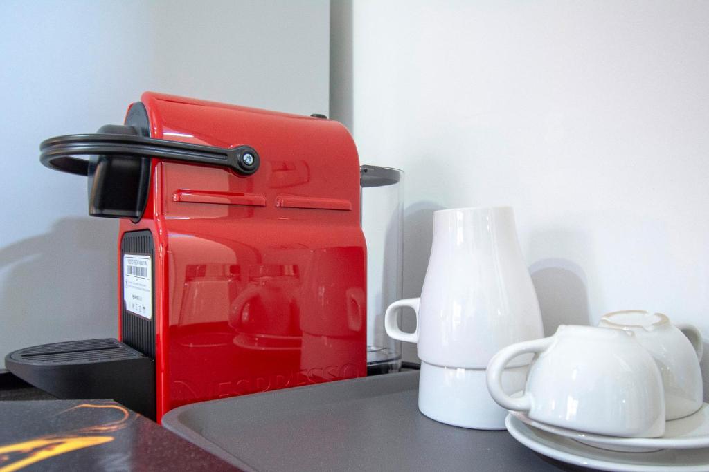 a red coffee maker sitting next to a white mug at Luxury Boutique Hotel in Rome