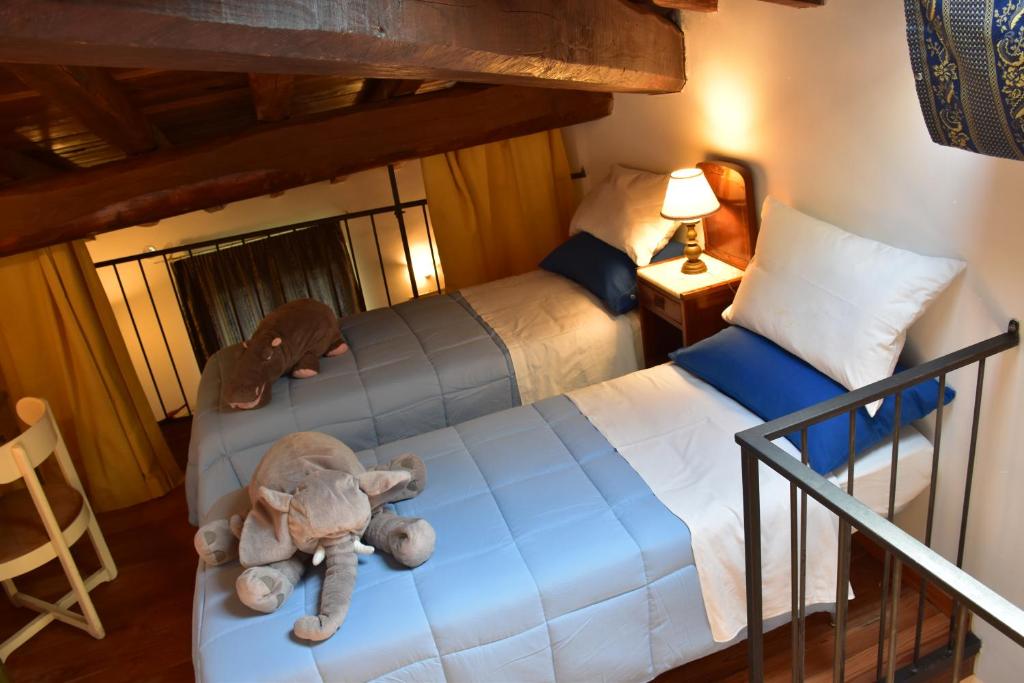 sypialnia z 2 łóżkami z wypchanym słoniem na wizorze w obiekcie Al Castello di Leprignano w mieście Capena