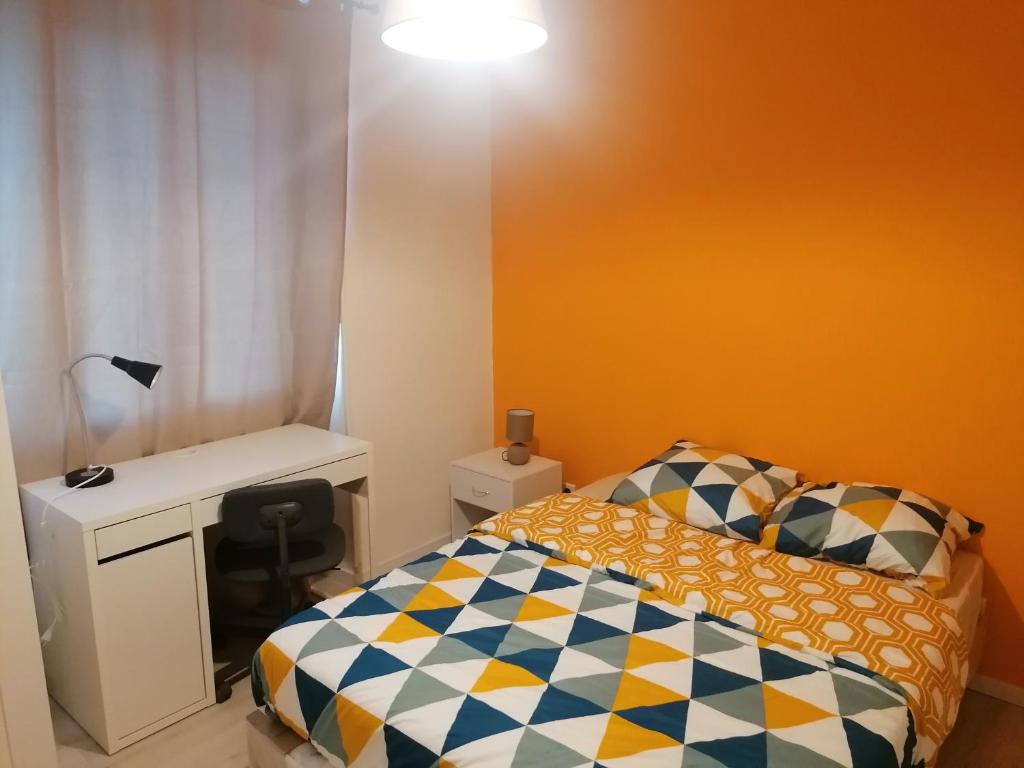 a small bedroom with a bed and a desk at SWEET Appartment avec Wifi et parking in Clermont-Ferrand