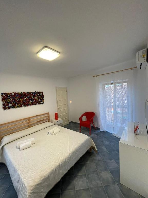 sypialnia z łóżkiem i czerwonym krzesłem w obiekcie Al Cortile w Cefalù